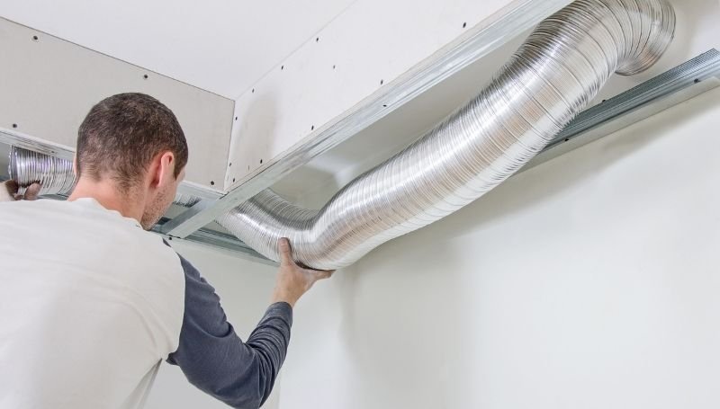 man setting up a flexible aluminum foil air ventilation duct