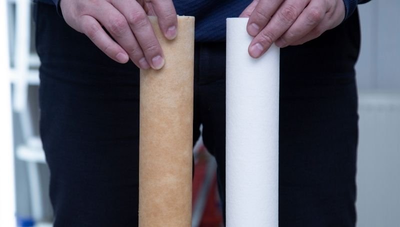 a person showing two gravity water filter cartridges: used (left) vs unused (right)